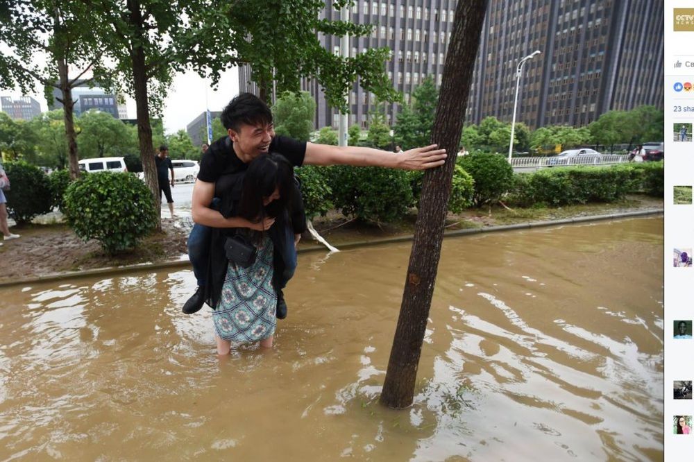 (FOTO) TAKO JE TO U KINI: Nosila momka kroz poplave da mu se ne pokvase cipele