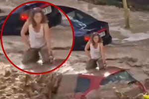 OVAKVO NEVREME ŠPANIJA NE PAMTI: Bujica nosi ženu zarobljenu na krovu vozila, jedva se drži, prolaznici nemoćno gledaju (VIDEO)