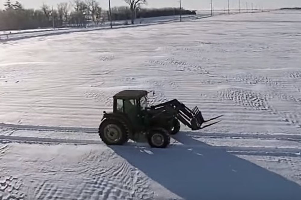 (VIDEO) Čovek je seo u traktor i krenuo da se vozi po snegu. Kad se kamera udaljila, nastao je šok
