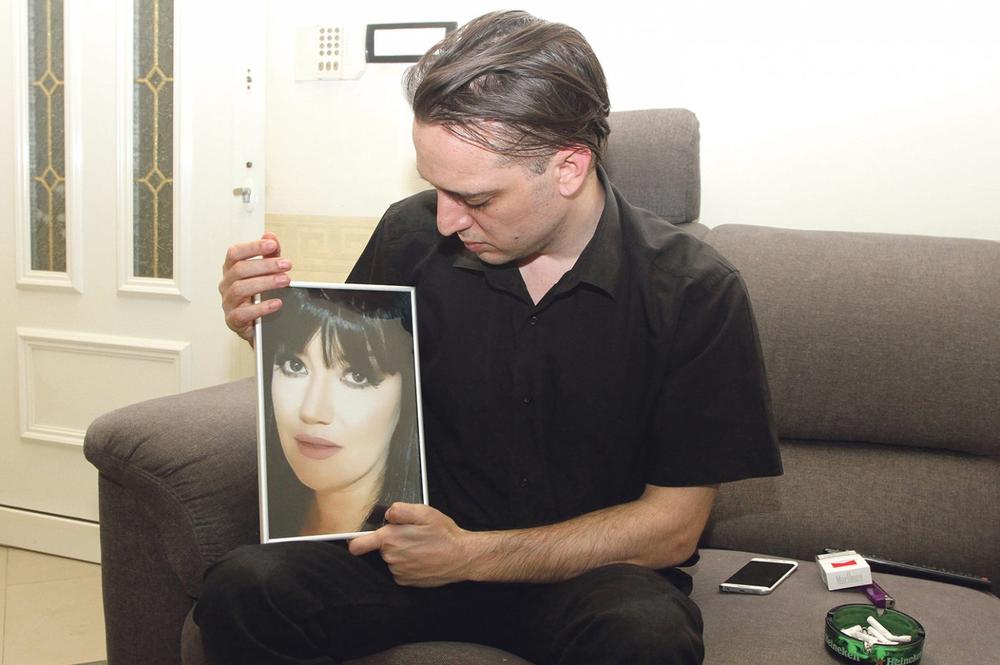 marjanović drži fotografiju ubijene supruge tokom davanja intervjua