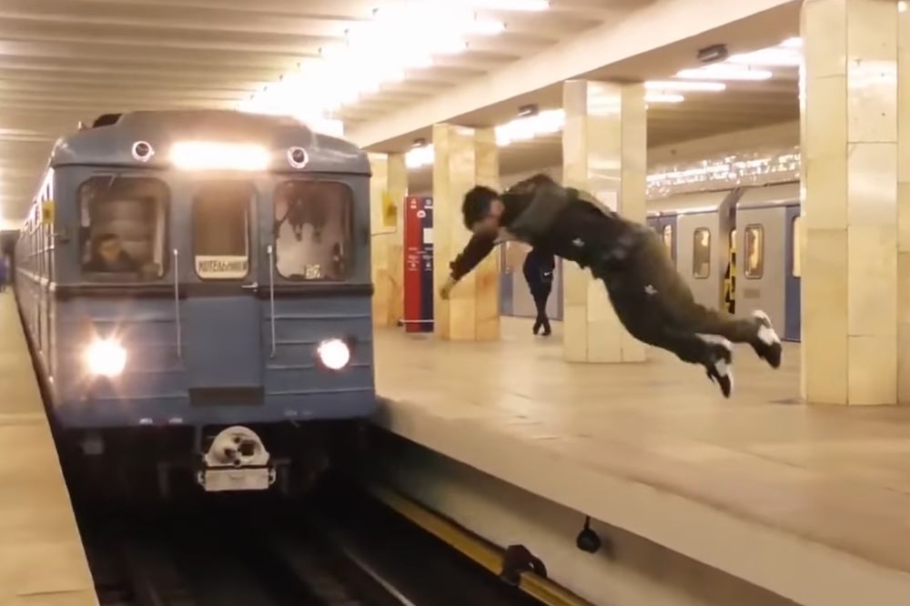 (VIDEO) PLES SA SMRĆU: Preskočio šine saltom, tik ispred voza... ZASTRAŠUJUĆE!