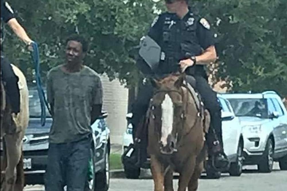 KAO U FILMOVIMA O DIVLJEM ZAPADU: Policajci na konjima kroz grad vode Afroamerikanca vezanog kanapom i posramljenog! Čovek je beskućnik i mentalno bolestan! (VIDEO)