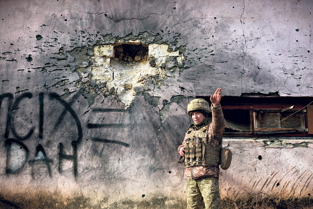 Posledice Ukrajinski vojnik kod oštećene zgrade