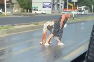 ZEMLJA GORI, ŽENA NE MOŽE DA PREĐE ULICU! Muž joj pomogao, jedva se pomerala, asfalt se istopio (VIDEO)